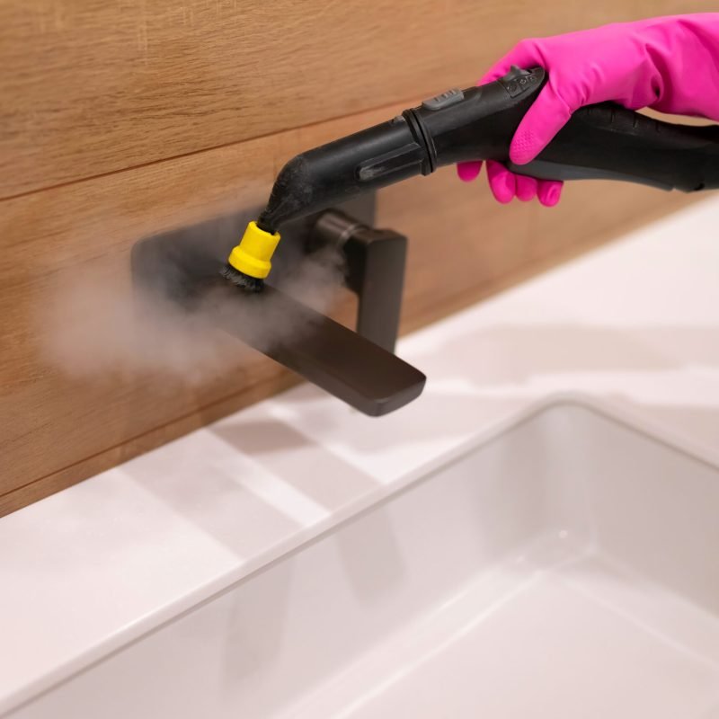 Cleaning the faucet from fungi and dirt with steam cleaner. Bathroom cleaning process Cleaning the faucet from fungi and dirt with steam cleaner. Bathroom cleaning process