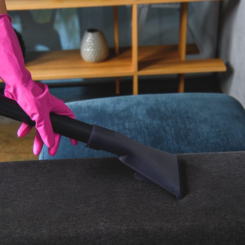 partial view of person in rubber glove cleaning furniture with vacuum cleaner partial view of person in rubber glove cleaning furniture with vacuum cleaner